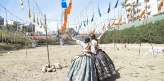 Dos falleras en Paiporta durante las Fallas 2026 con decoraciones festivas