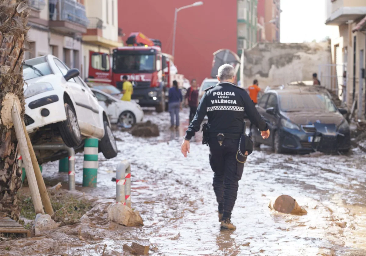 Un policía local de Valencia ayuda en un municipio afectado por inundaciones.