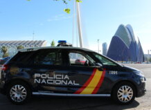 Vehículo de la Policía Nacional en Valencia con arquitectura moderna de fondo