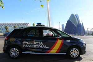 Vehículo de la Policía Nacional en Valencia con arquitectura moderna de fondo