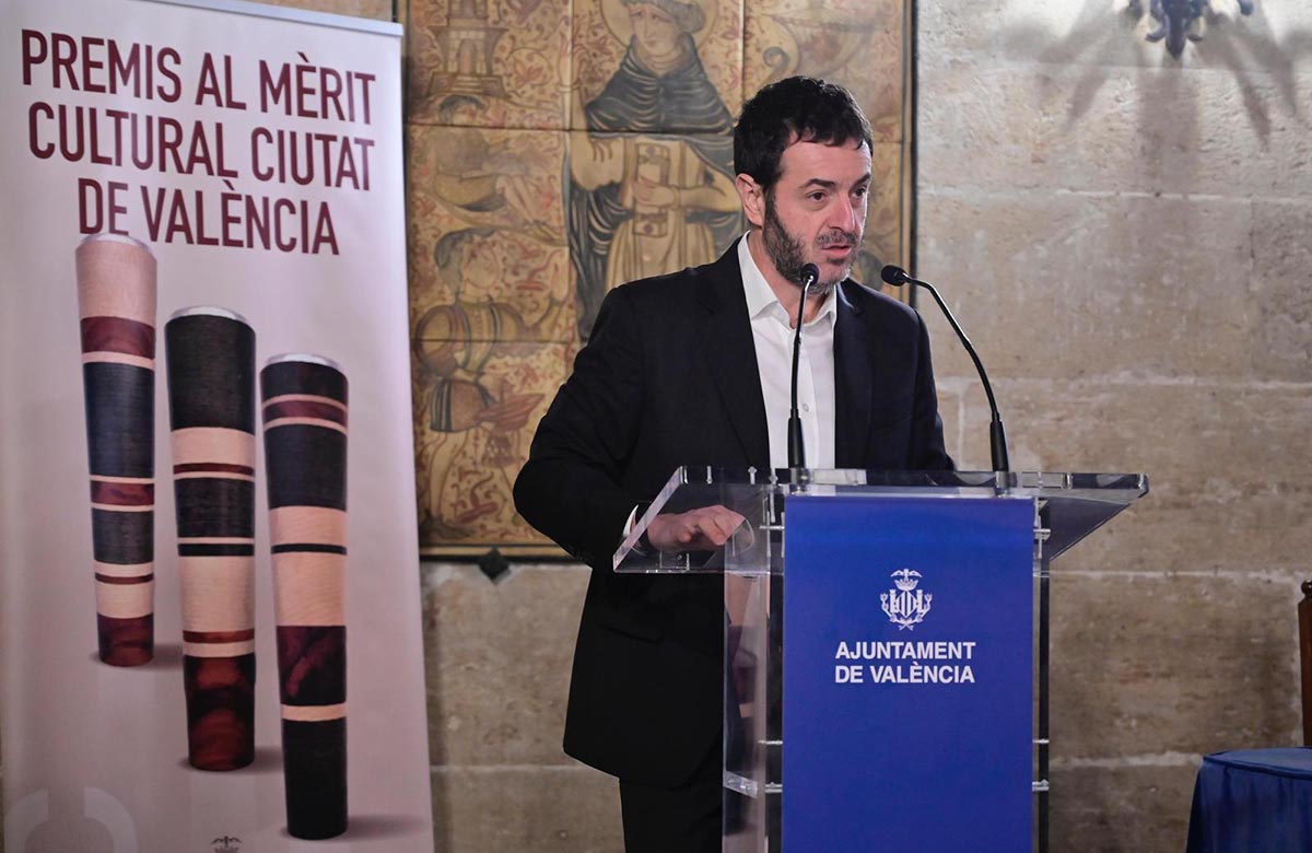 Entrega de premios al Mérito Cultural en Valencia con un ponente en el podio.