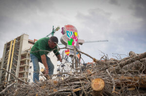 Hombre preparando la hoguera de Sant Antoni en La Pobla de Farnals