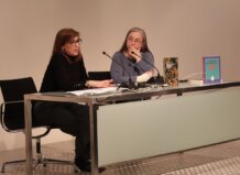 Dos mujeres en una mesa discutiendo sobre patrimonio bibliográfico valenciano.