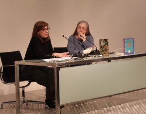 Dos mujeres en una mesa discutiendo sobre patrimonio bibliográfico valenciano.