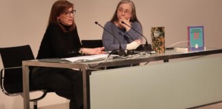 Dos mujeres en una mesa discutiendo sobre patrimonio bibliográfico valenciano.