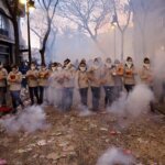 Grupo de personas en una protesta con humo y confeti en la calle