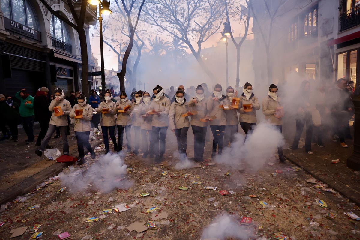 Grupo de personas en una protesta con humo y confeti en la calle