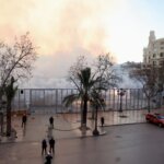 Vista de una protesta en la ciudad con humo y barricadas