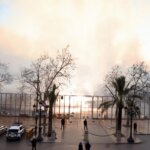 Vista de una protesta con niebla y presencia policial.