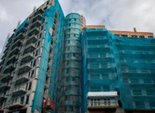 Dos años del incendio de Campanar, el búnker renace frente a una ley sin cambios para evitar nuevas tragedias Edificio en rehabilitación en el barrio de Campanar, Valencia, cubierto con mallas de protección.