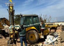 Agentes de la Guardia Civil investigan una retroexcavadora robada en Picassent.