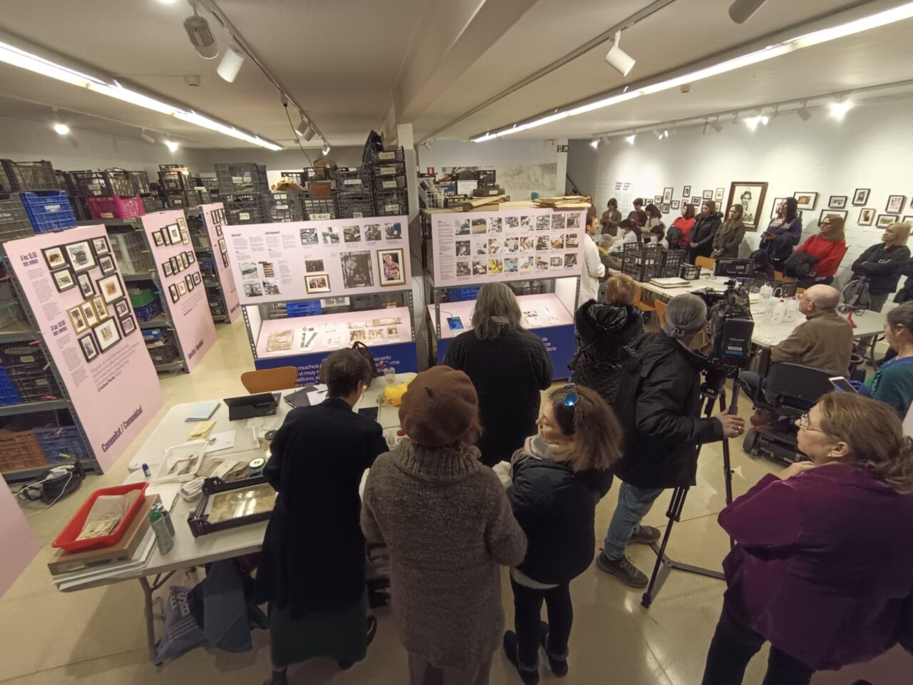 Vista de una exposición con participantes observando fotografías en un museo