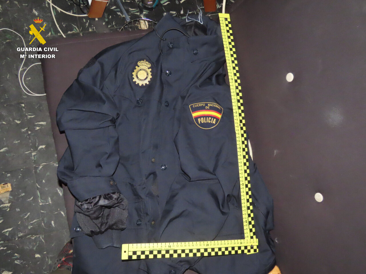 Uniforme de la Policía Nacional con insignia y cinta de medición