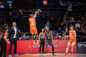 Jugador de Valencia Basket lanzando un tiro de baloncesto en un partido.