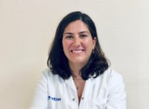 Experta de Vithas advierte que los problemas digestivos podrían ser un desencadenante clave en las migrañas Doctora sonriente con bata blanca en un fondo claro