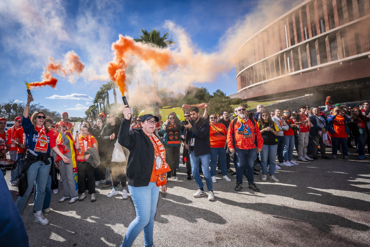Celebración de aficionados del Valencia Basket femenino con bengalas naranjas