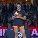Jugadora de Valencia Basket femenino sosteniendo trofeo en celebración