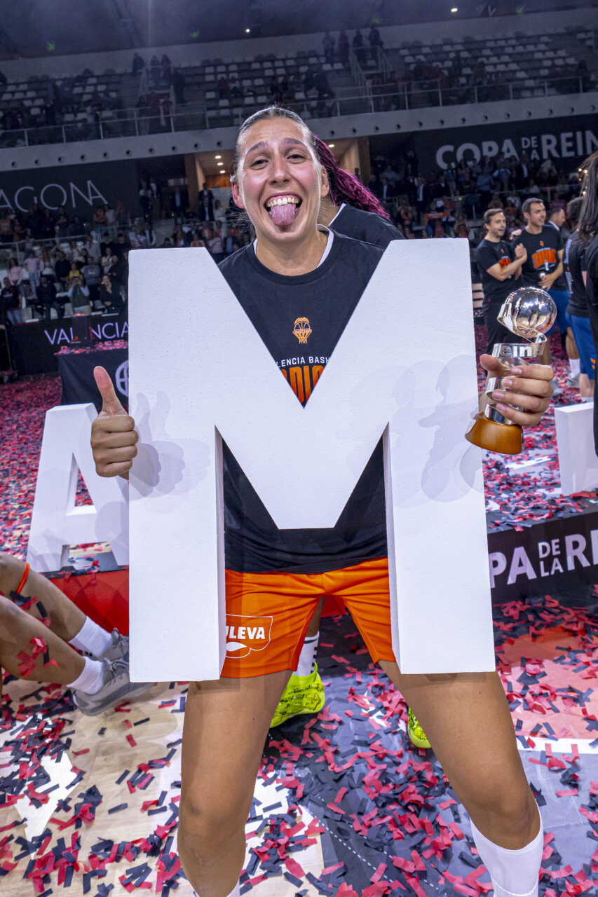 Jugadora de Valencia Basket celebra con trofeo y letra M
