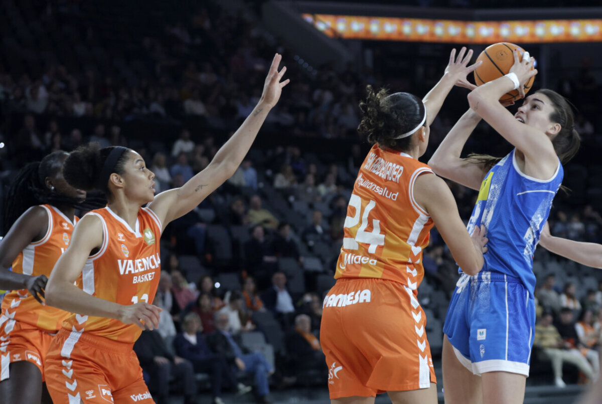 Jugadoras de Valencia Basket defendiendo a una oponente en un partido de baloncesto