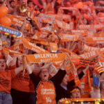 Aficionados del Valencia Basket celebrando con bufandas naranjas
