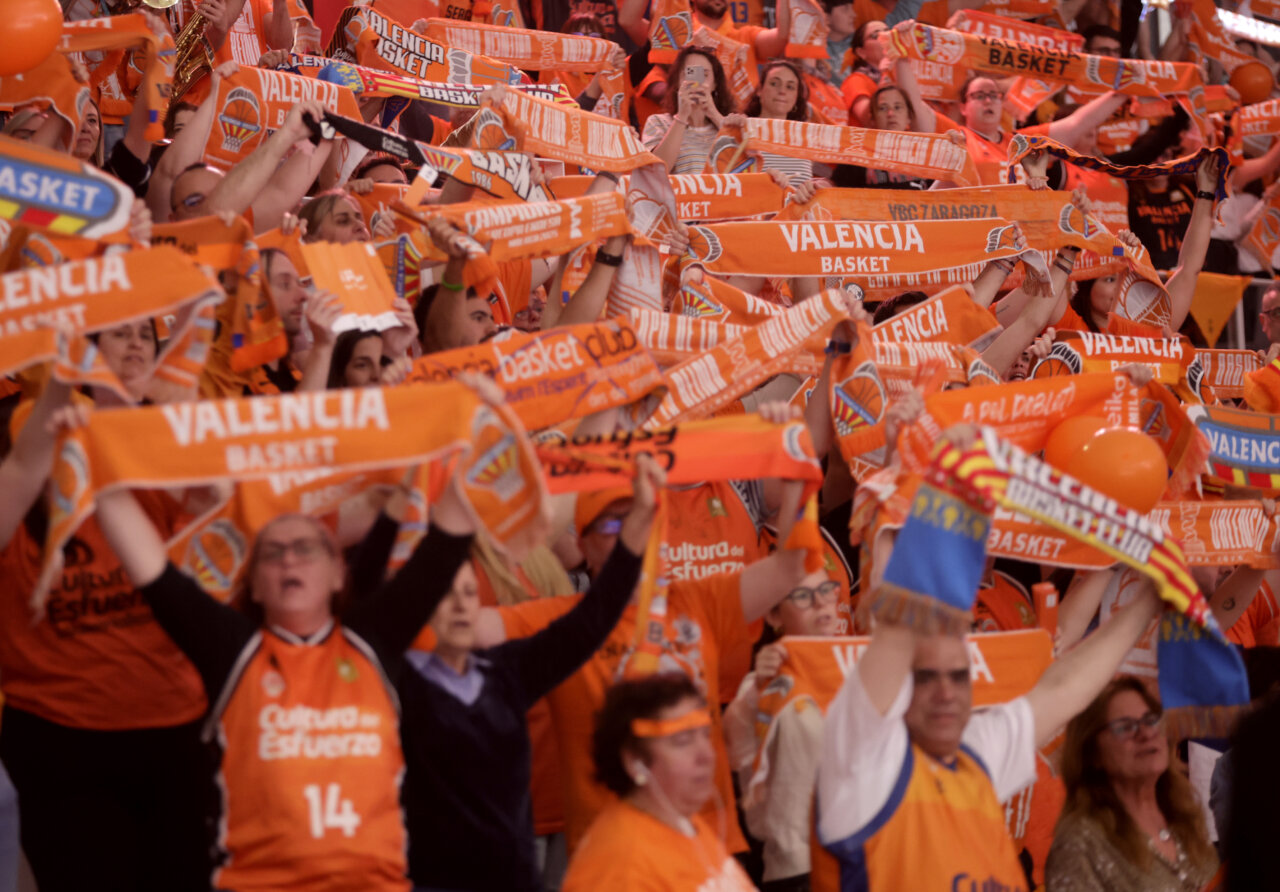 Aficionados del Valencia Basket celebrando con bufandas naranjas