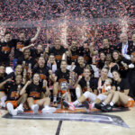 Equipo de Valencia Basket celebra su victoria en la Copa de la Reina con trofeos y confeti.