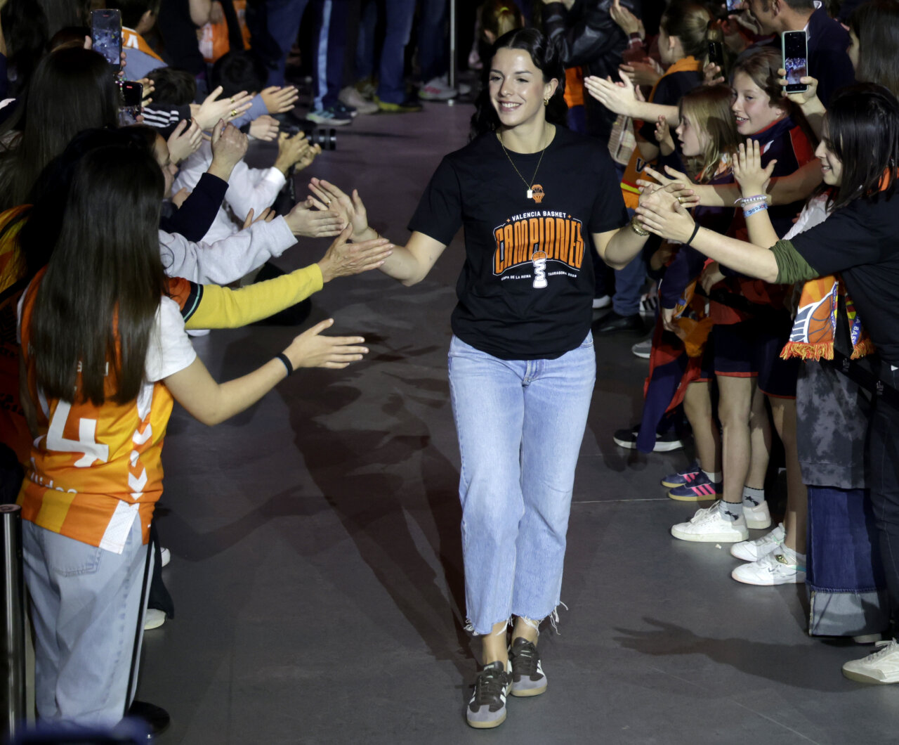 Jugadora de Valencia Basket celebrando con aficionados en el Roig Arena