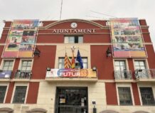 Fachada del Ayuntamiento de Rafelbunyol con banderas y cartel