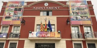 Fachada del Ayuntamiento de Rafelbunyol con banderas y cartel