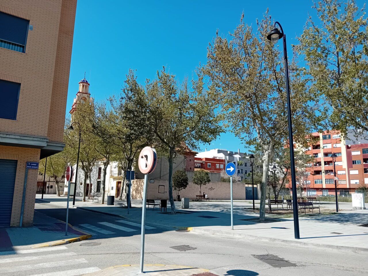Vista de las calles de La Pobla de Farnals con árboles y edificios