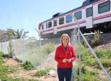 El nuevo cerramiento de la línea C-3 en Xirivella reabre la exigencia de una conexión subterránea con el polideportivo Mujer de pie junto a un vallado con tren en el fondo en Xirivella