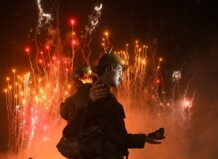 Monumento fallero con fuegos artificiales de fondo en Valencia