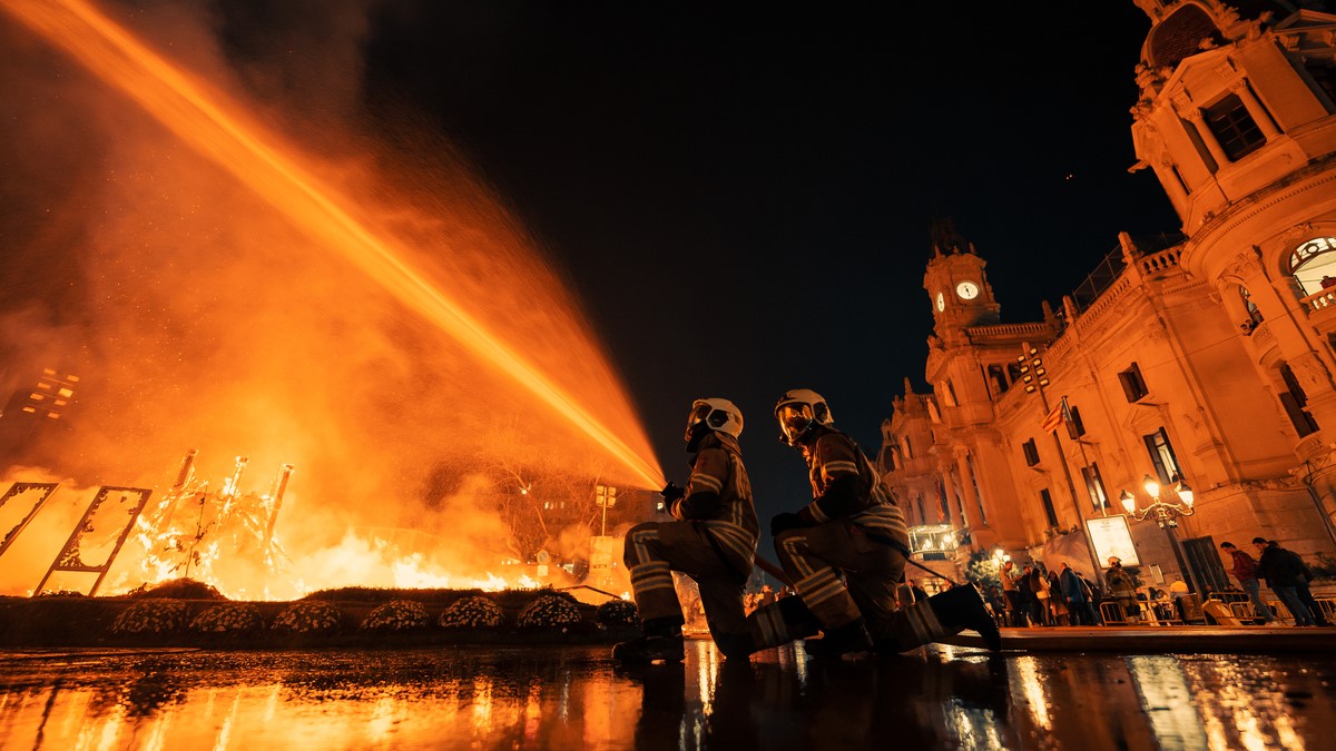 Bomberos apagando el fuego durante la Nit de la Cremà en Valencia.