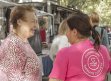 Interacción entre cuidadora y persona mayor en un mercado local
