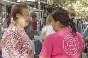 Interacción entre cuidadora y persona mayor en un mercado local