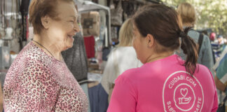Interacción entre cuidadora y persona mayor en un mercado local