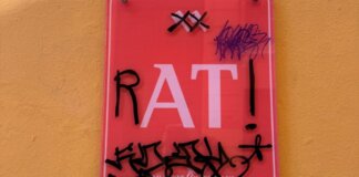 Cartel vandalizado con la palabra RAT en Valencia