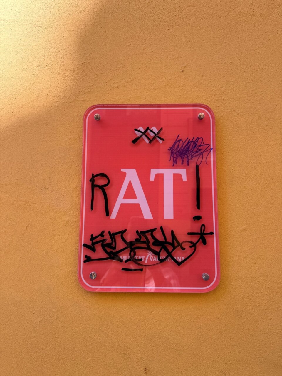 Cartel vandalizado con la palabra RAT en Valencia