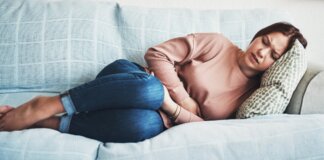 Mujer con dolor abdominal en un sofá