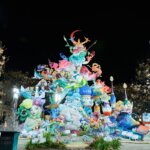 Fallas 2026 en Valencia, monumento iluminado de colores vibrantes.