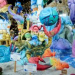 Fallas 2026 con figuras coloridas y personajes animados.