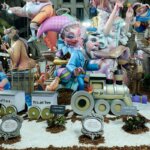 Fallas 2026 con figuras coloridas y un tren en la escena