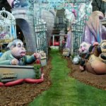 Fallas 2026 con figuras caricaturescas en un jardín