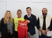 Eduardo L. Gómez posando con su equipo y camiseta en un evento deportivo
