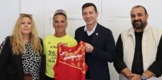 Eduardo L. Gómez posando con su equipo y camiseta en un evento deportivo