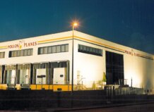 Fachada de la empresa Pollos Planes en Massamagrell iluminada por la noche