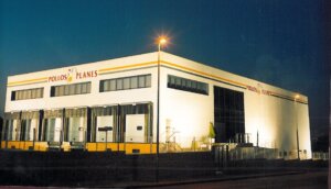 Fachada de la empresa Pollos Planes en Massamagrell iluminada por la noche