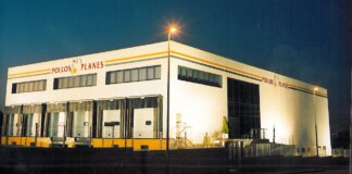 Fachada de la empresa Pollos Planes en Massamagrell iluminada por la noche