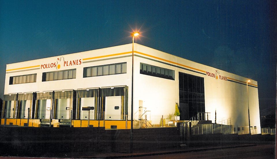 Fachada de la empresa Pollos Planes en Massamagrell iluminada por la noche