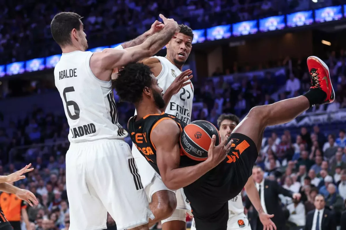 Jugadores de Valencia Basket y Real Madrid en un intenso partido de EuroLeague.